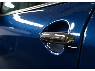 Machine à polir rotative sur une carrosserie de voiture, en train de retirer les rayures et de restaurer la brillance