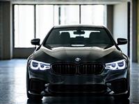 Une élégante berline noire de luxe, fraîchement nettoyée, reflétant son environnement avec brio, symbolisant l'attention aux détails pour les véhicules de direction.