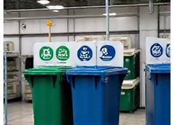 Bacs de tri sélectif pour les déchets, avec des pictogrammes environnementaux, dans un environnement propre et organisé, illustrant la gestion responsable des déchets chez AquaCleanse.