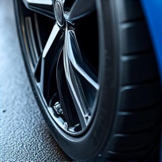 Pneus de voiture noirs et brillants après application d'un produit de dressing professionnel.